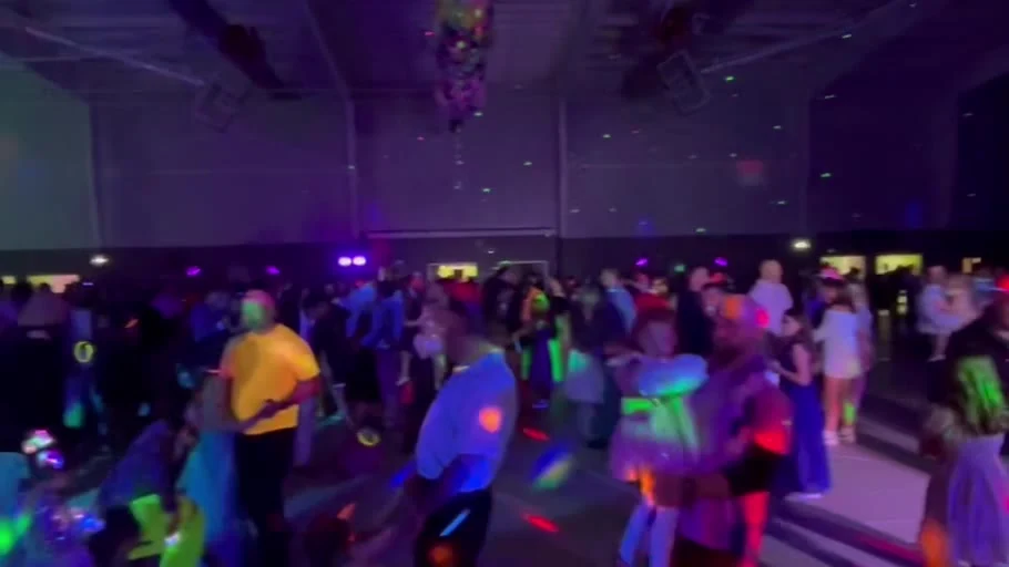 Families dancing beneath colorful party lights